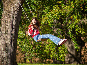 student in red sweater on a swing