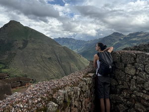 Bella Wells Fried in front of a green and blue mountainous landscape in Cusco, Peru
