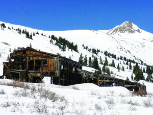 An abandoned wooden mill in a snowy landscape