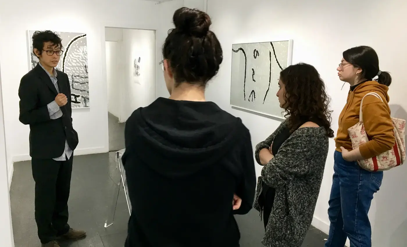 students speaking with gallerist at exhibition