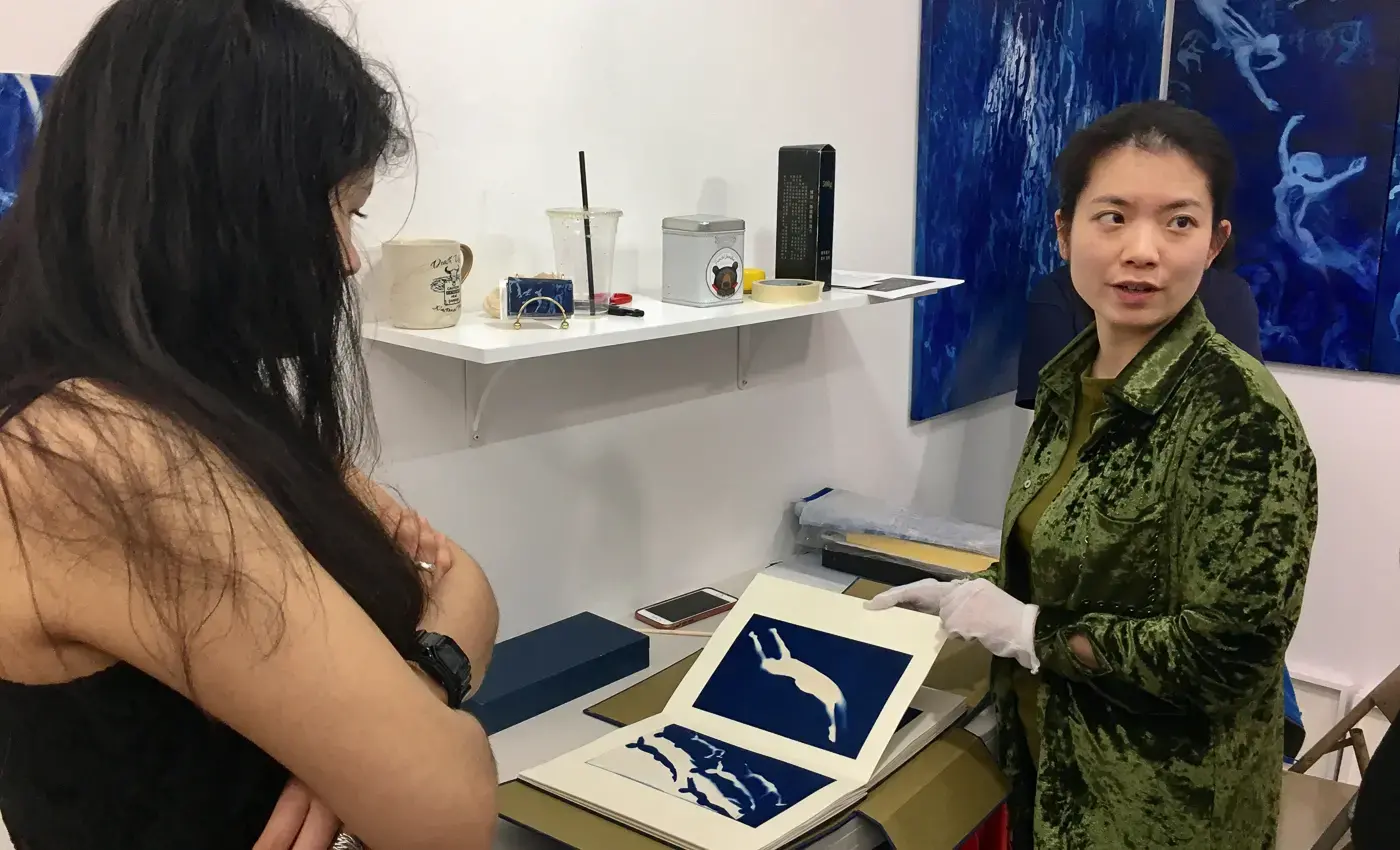 student speaking with artist during studio visit