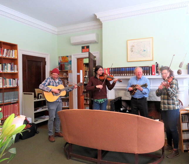three musicians performing in the music library