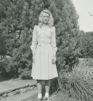 black and white photo of a young woman wearing a white dress. 