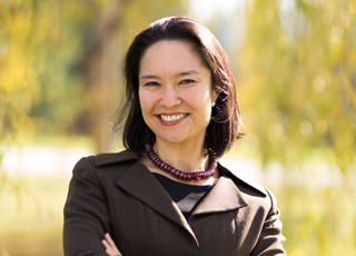 Mariko Silver smiling with blurred foliage in background