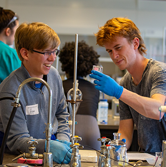 Two students work together on a chemistry experiment