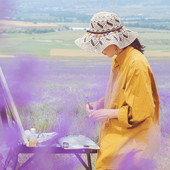 a woman paints outside in a field