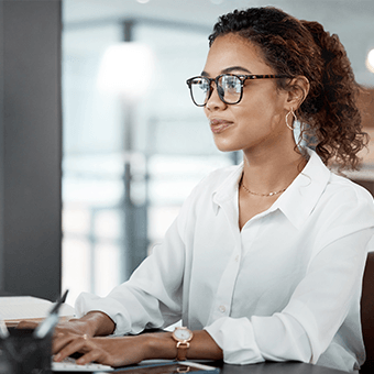 a woman sits at a computer and types
