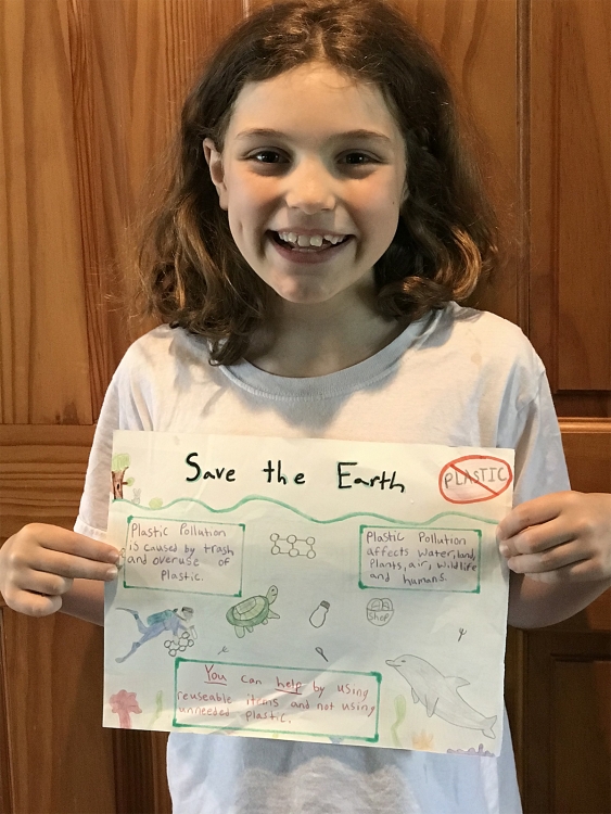 Photo of student holding earth day poster