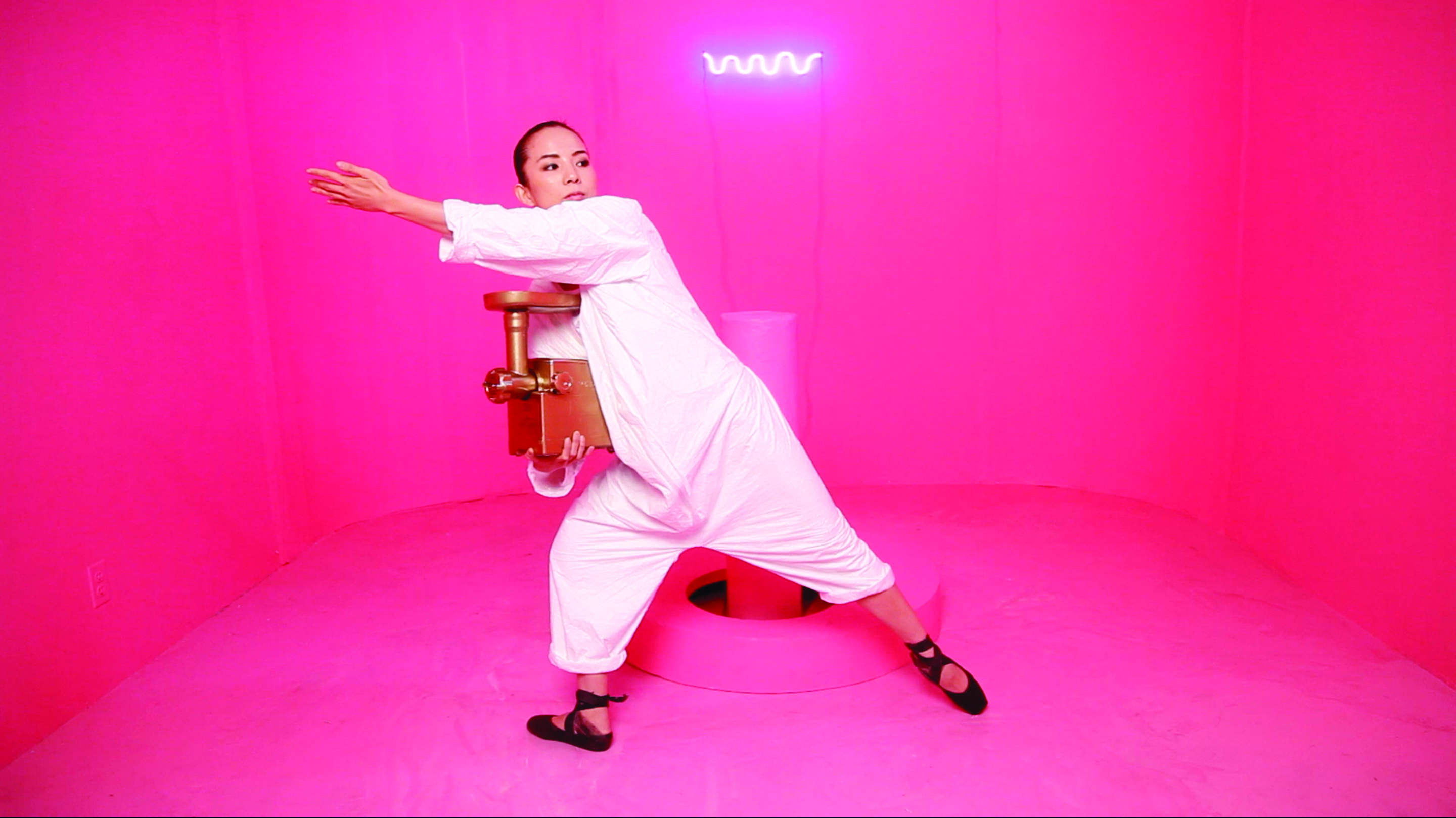 dancer in white in a very pink room