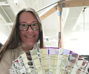 Amanda Bacon '19 with a dichroicon, a Winston-style light concentrator built out of dichroic filters, which could allow large-scale neutrino detectors to sort photons by wavelength with small overall light loss.