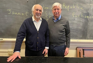 Image of two men in front of chalkboard