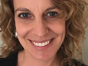 Smiling woman with curly hair against white background