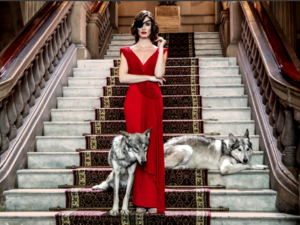 woman in fancy red dress on fancy grand staircase with wolves