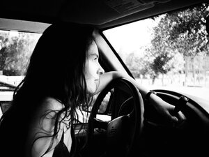 Amy Anders - woman with long dark hair in the driver's seat of a car