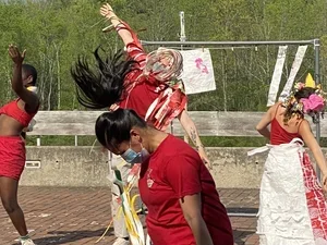 dancers in red clothes improvising on a patio