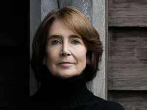 Woman with brown hair wearing a black turtleneck by Beowulf Sheehan 