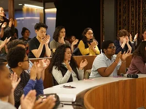 Group of students sitting in a tiered ring clapping