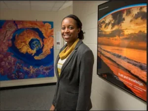 Yolanda Shea, smiling woman in front of colourful images hung on the walls