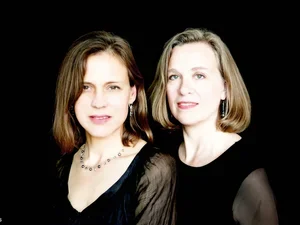 image of two female musicians in black against a black background