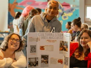 three students welcome admitted students at a tabling event