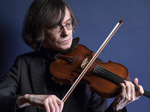 Rolf Schulte playing the violin against a blue background