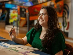 a student welcomes admitted students at a tabling event