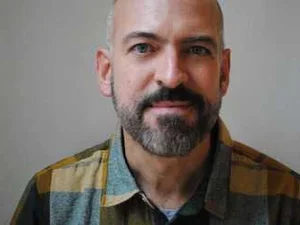 Photo of Paul Lisicky, bearded, starting at the camera