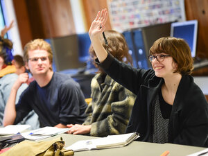 student raising their hand in class