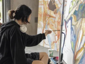 two students painting on canvas
