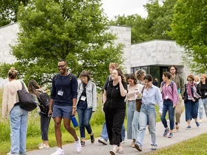 a large group of students walk from class outside on the sidewalk