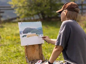 a student painting landscapes outside