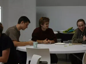 Three students discussing project around a table