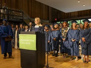 Image of Laura Walker at podium in front of graduates