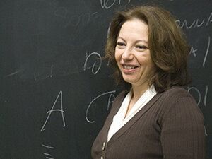 Image of woman in front of chalkboard