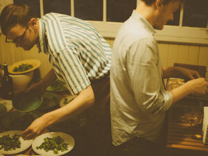 Andrew Barton and childhood friend plating green sage flowers in the backroom
