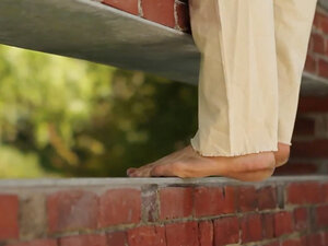Close-up of dancer's bare feet on brick wall
