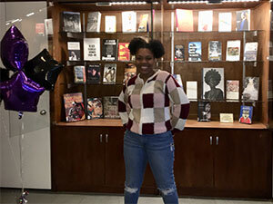 Deja' Haley in front of Black library display