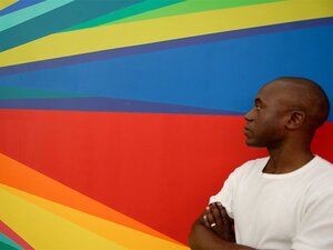 Odili Donald Odita in front of his own colourful painting