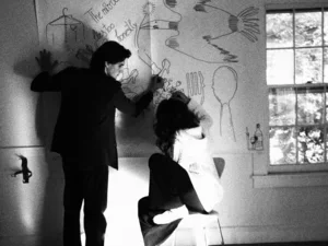 Polina Stolar '27 and Thelonious Shores '27 against wall of text