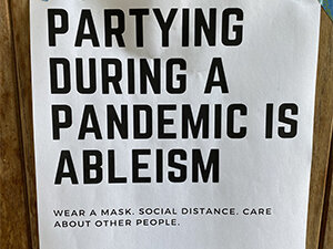 Image of sign partying during a pandemic is ableism
