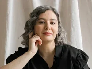 Photo of the writer and translator Bruna Dantas Lobato with her chin resting on her hand 