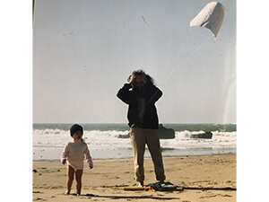 Image of young girl and man flying a kite on the beach