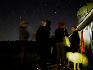 Students observing night sky outside observatory