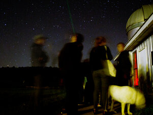 Students observing night sky outside observatory