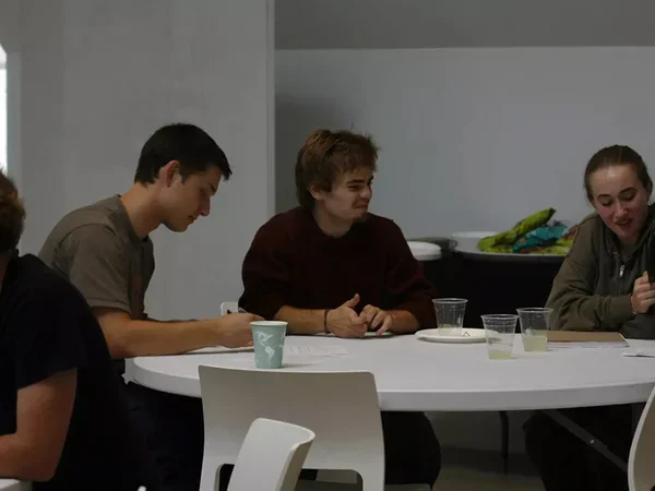 Three students discussing project around a table