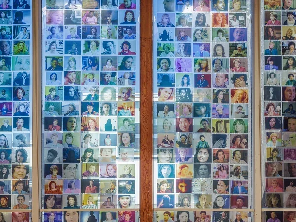 Image of women's photographs printed on transparency in a window from Double Jeopardy, an exhibition by  Carmen Winant at Usdan Gallery of Bennington College