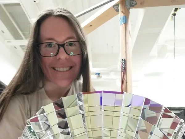 Amanda Bacon '19 with a dichroicon, a Winston-style light concentrator built out of dichroic filters, which could allow large-scale neutrino detectors to sort photons by wavelength with small overall light loss.