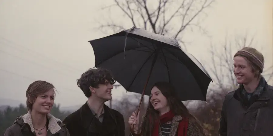 four students under an umbrella