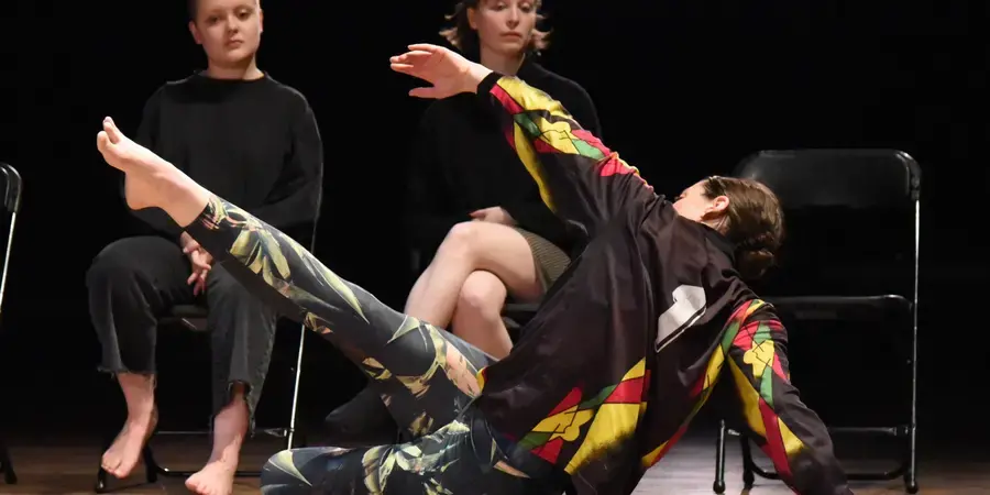 two dancers on stage, two students observe