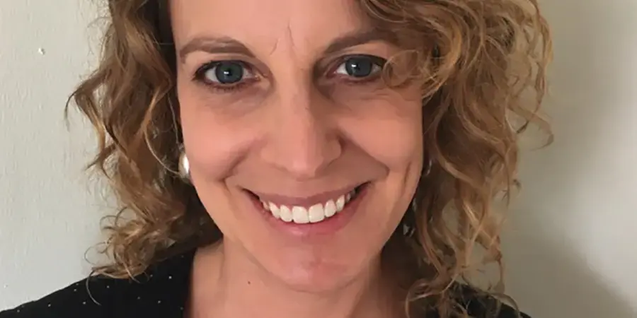 Smiling woman with curly hair against white background